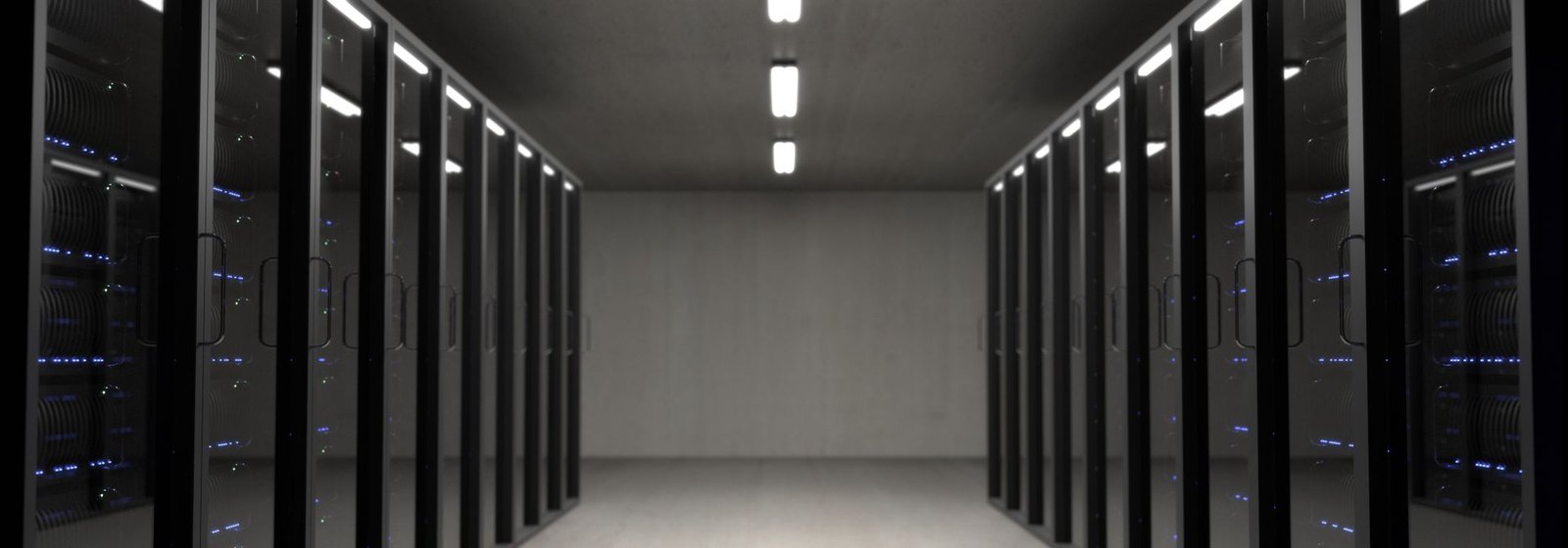 Data centre server room hallway with racks lit by blue and green LEDs